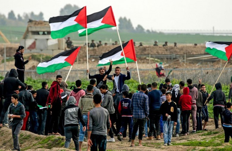 مشاركون في فعاليات مسيرات العودة أمام جنود الاحتلال